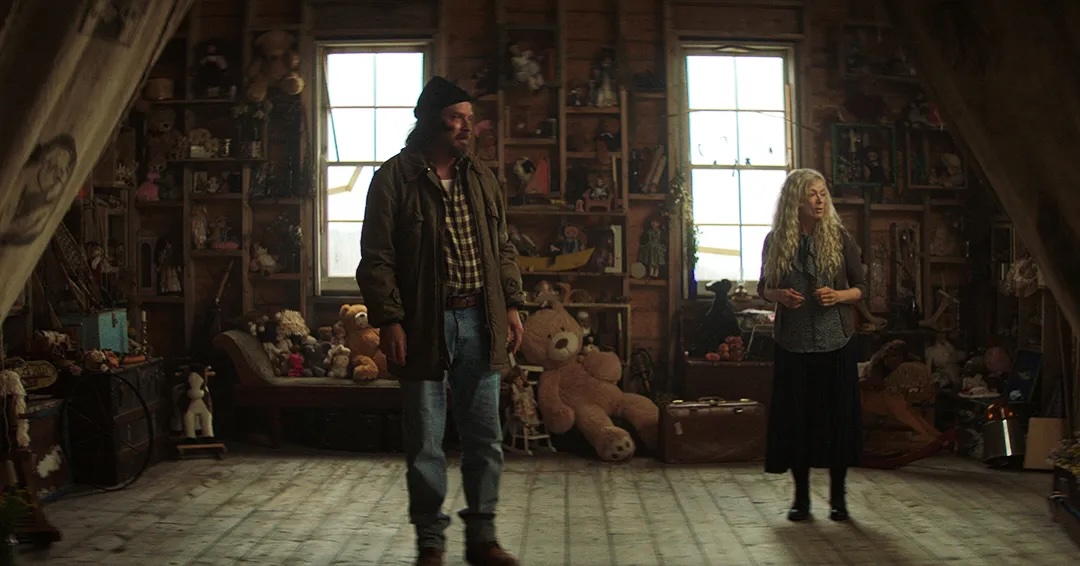 Beau (Aden Young - L) stands in a room full of children's toys with Faye (Frances Fisher)