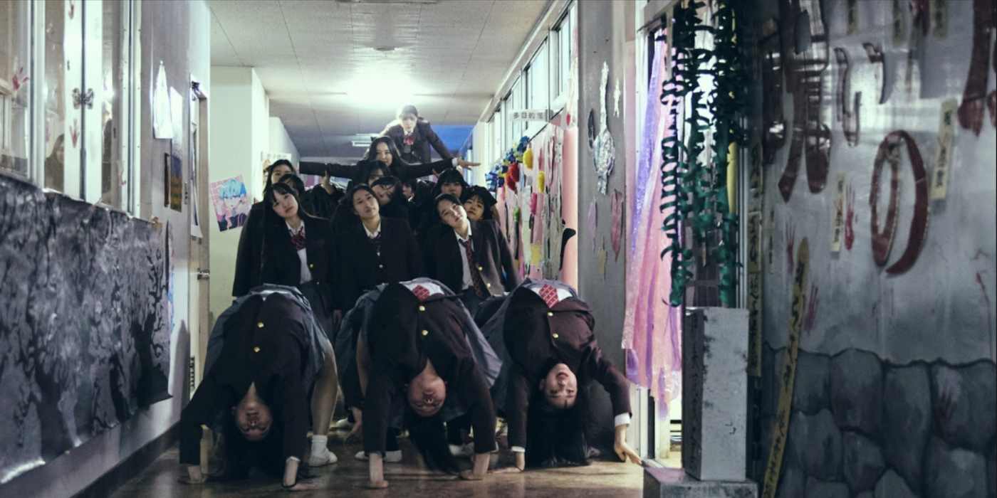 A human pyramid travels through the hallway in New Group review